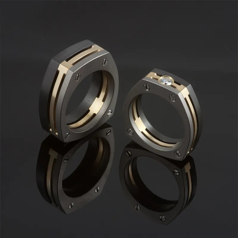 Ringen-Trinity-Symetric-zwart-zirkonium-geelgoud-en-titanium.-Damesring-bezet-met-diamant.